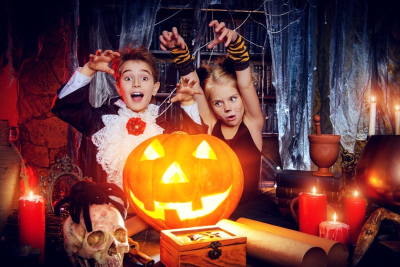 Дети в комнате украшенной для Хэллоуина